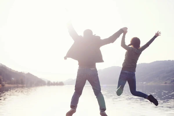 Casal saltando no lago — Fotografia de Stock