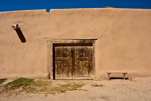 Adobe gebouw met oude deur en Bank — Stockfoto