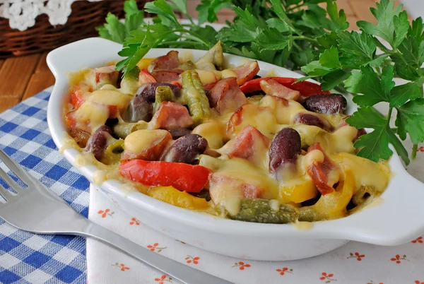 Feijões com presunto e legumes, assados com queijo — Fotografia de Stock