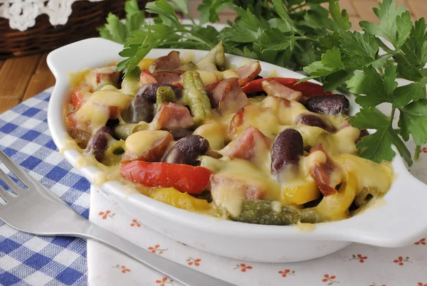 Feijões com presunto e legumes, assados com queijo — Fotografia de Stock