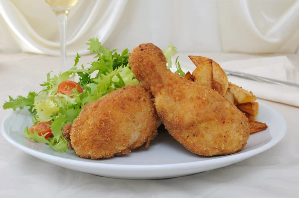 Chicken drumsticks with breadcrumbs with potatoes and salad — Stock Photo, Image