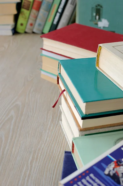 Разнообразие книг в стопках на столе — стоковое фото
