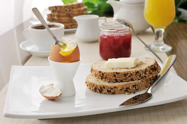 与半熟的鸡蛋早餐和燕麦面包切片 — 图库照片