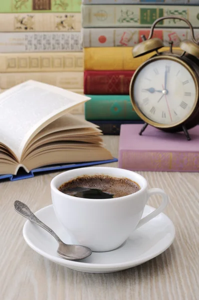 Ένα φλιτζάνι καφέ σε ένα τραπέζι μεταξύ βιβλία — Φωτογραφία Αρχείου