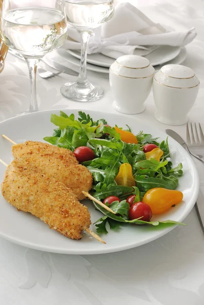 Garnering van arugula en tomaten met kippenschnitzel — Stockfoto