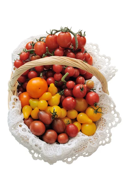 Different varieties of tomatoes in a basket — Stock Photo, Image