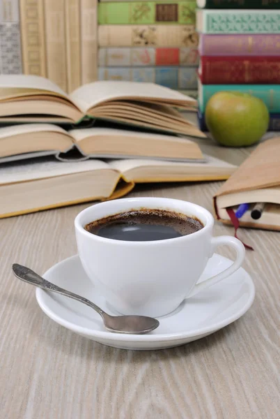 Une tasse de café sur une table parmi les livres — Photo
