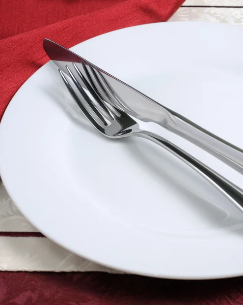 Knife and fork on a white plate — Stock Photo, Image