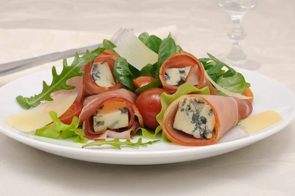 Rolls of jamon with blue cheese in lettuce leaves and parmesan — Stock Photo, Image
