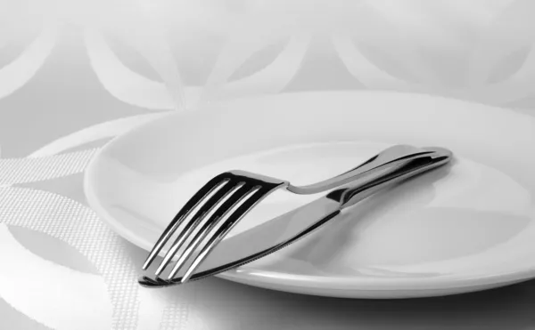Knife and fork on a plate Stock Photo