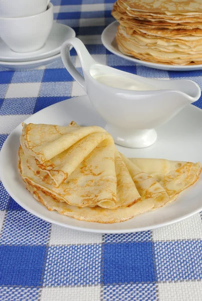 Pfannkuchen auf einem Teller mit Milchsoße — Stockfoto