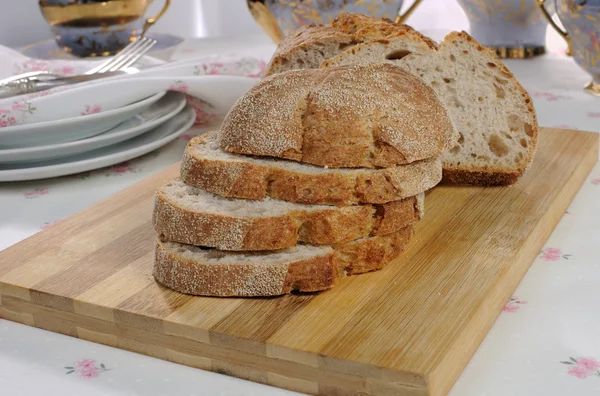 Ломтики овсяного хлеба на деревянной доске — стоковое фото
