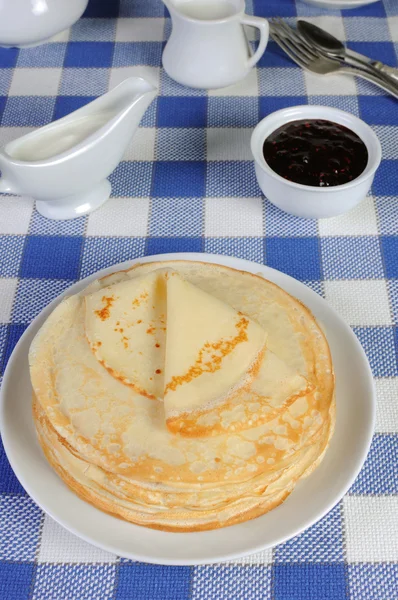 Pfannkuchen auf einem Teller mit Milchsoße — Stockfoto