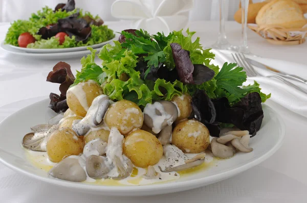 Batatas de bolas com cogumelos e molho de creme em folhas de alface — Fotografia de Stock