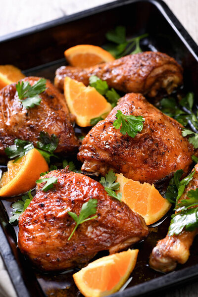 аппетитные ломтики запеченного цыпленка с хрустящей жареной корочкой и апельсинами в хлебном листе