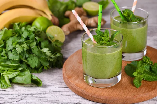 Taze organik detoks yeşil içecek smoothie ile kereviz, ıspanak, muz, kişniş, limon ve naneli zencefil. Sağlıklı, besleyici, vejetaryen yiyecekler.