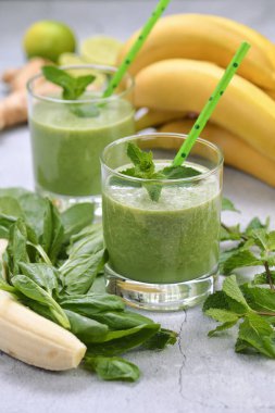 Taze organik detoks yeşil içecek smoothie ile ıspanak, muz, limon ve ferahlatıcı naneli zencefil. Sağlıklı, besleyici, vejetaryen yiyecekler.
