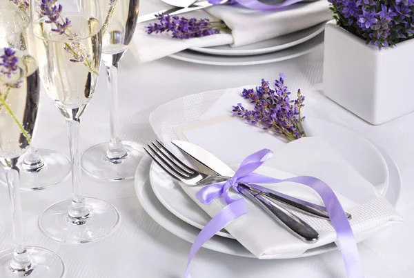 Lavender mood. Dining table in Provence style, with Lavender Champagne, folded napkin with cutlery, decorated with fresh lavender. Detail of the wedding dinner. Wedding theme ideas.