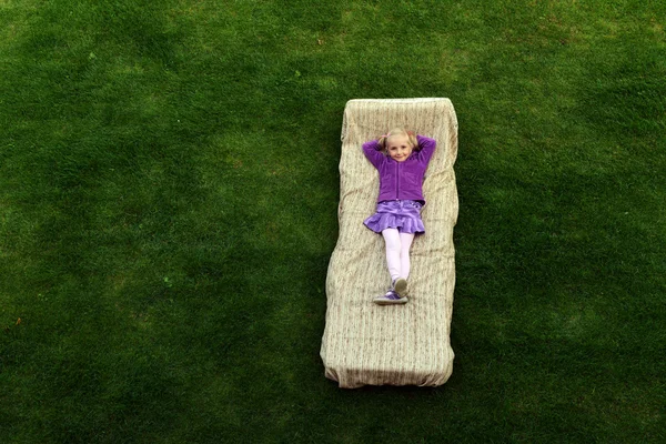 Girl lies on mattress — Stock Photo, Image