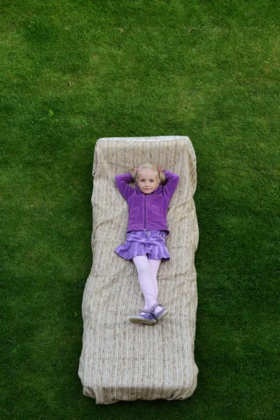 Meisje ligt op matras — Stockfoto