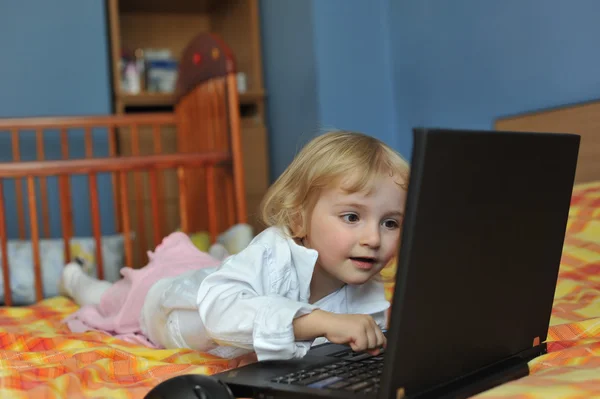 Pieni tyttö kannettavan tietokoneen kanssa — kuvapankkivalokuva