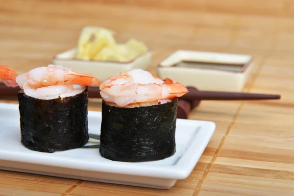 Dish with fresh sushi rolls on bamboo napkin background — Stock Photo, Image