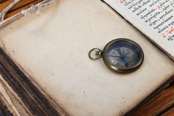 Kompas en horloge op oude boek — Stockfoto