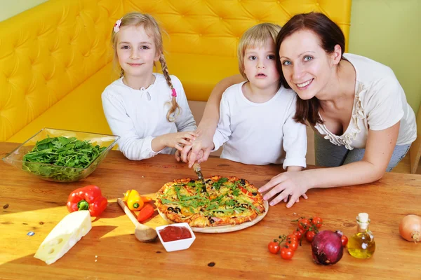Madre con niños que se preparan para comer pizza fresca —  Fotos de Stock