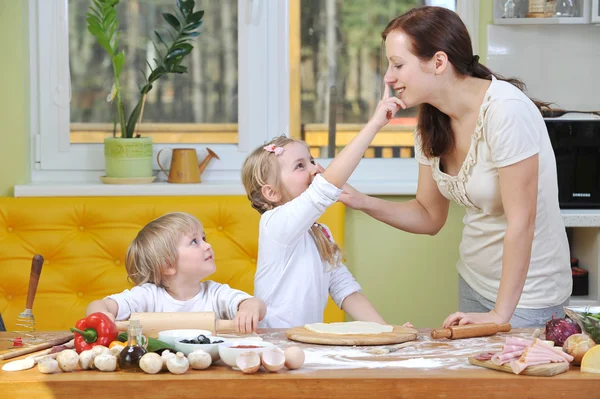 Mother with children preparing pizza — Stock Photo, Image