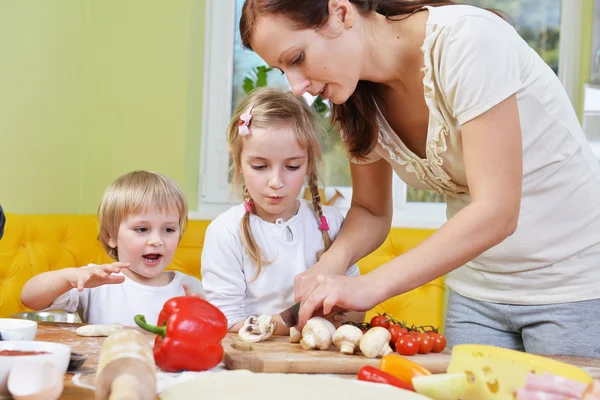 Madre con hijos cortar verduras —  Fotos de Stock