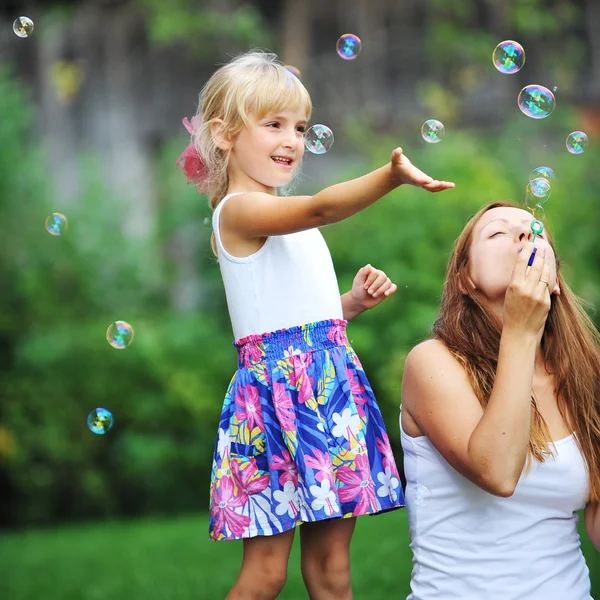 Mother and daughter play with bubbles — Stock Photo, Image