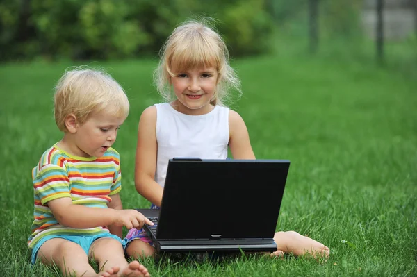 Niña con hermano con portátil — Foto de Stock