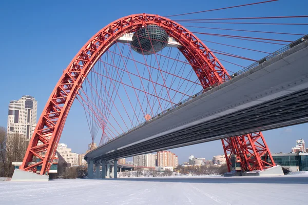 Visa röda arc Bridge på frysta moskva-floden och många byggnader — Stockfoto