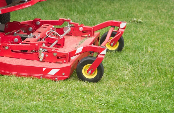 Lawnmower cuts a green garden grass closeup — Stock Photo, Image