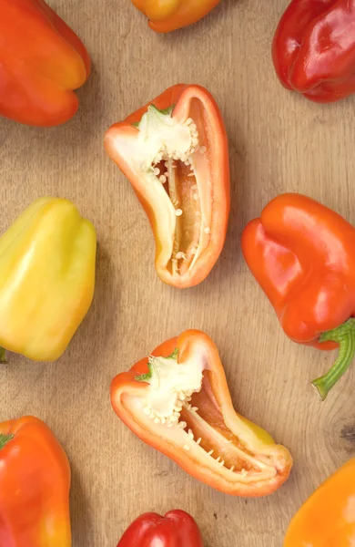 Many tasty sweet peppers on brown kitchen desk — Stock Photo, Image