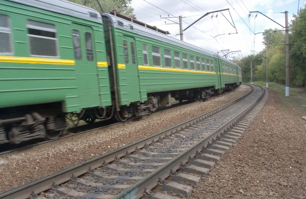 Groene trein snel beweegt op spoorweg — Stockfoto