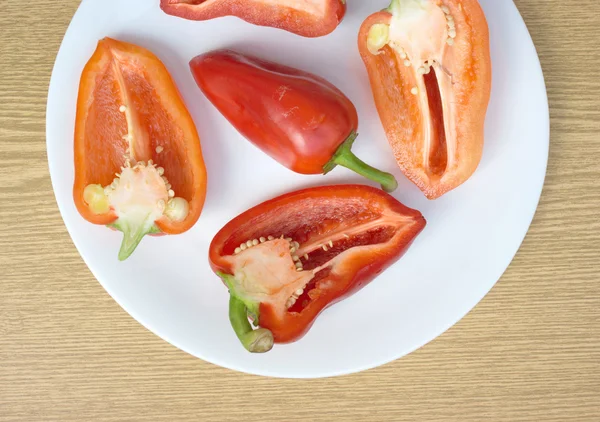 Tasty sweet peppers on white plate top view closeup — Stock Photo, Image
