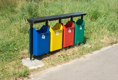 bir parkta renkli çöp konteynırları