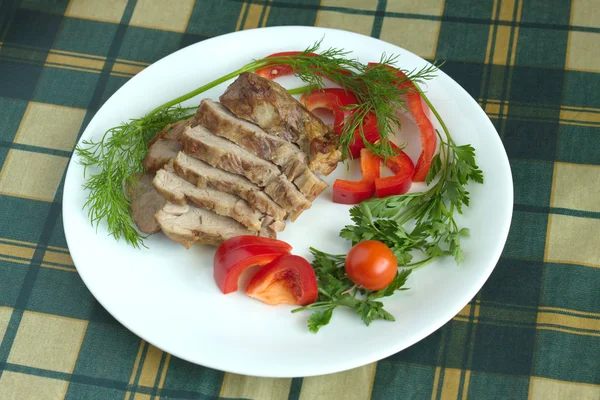 Plate with stew and vegetables on green plaid tablecloth — Stock Photo, Image