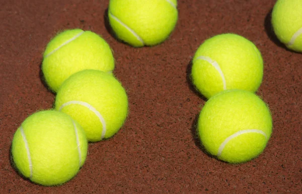 Piłki tenisowe żółty na brązowy sąd zbliżenie — Zdjęcie stockowe