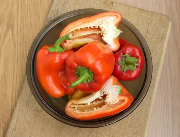 Sliced and whole peppers in a bowl — Stock Photo, Image