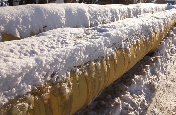 Two yellow frozen pipes in winter closeup