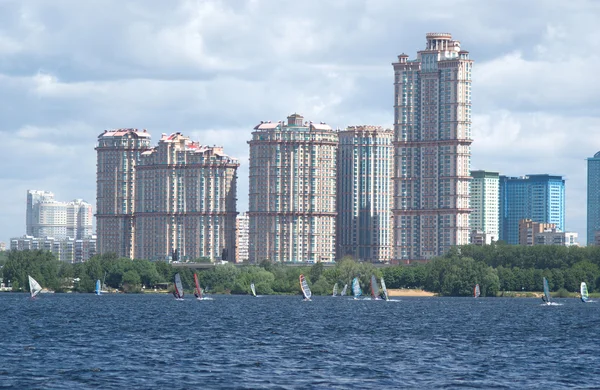 Paisagem urbana com casas modernas e pranchas de surf em um rio — Fotografia de Stock