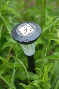 Solar power lantern outdoor in grass closeup clipart