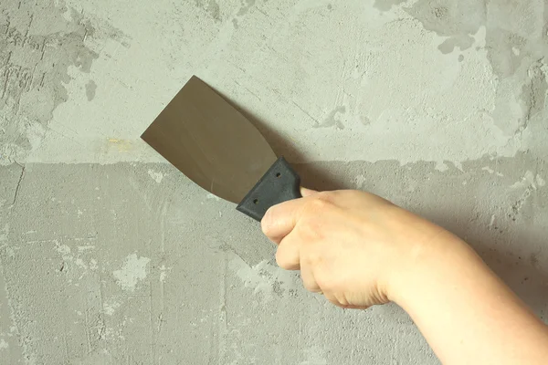 Mano de mujer con pared de yeso de espátula — Foto de Stock