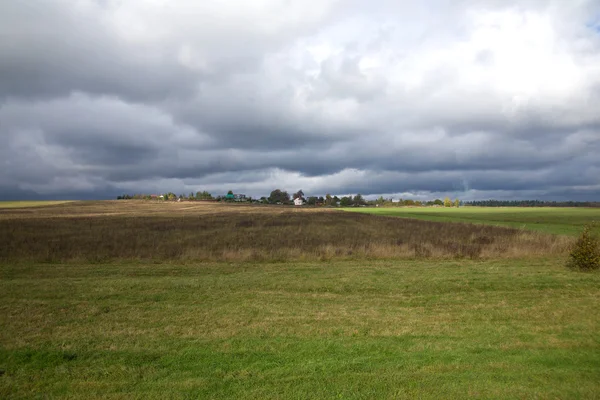 Paisaje con nubes oscuras sobre el campo —  Fotos de Stock