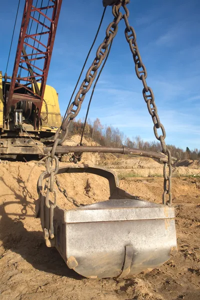 Big heavy excavator bucket and mountain of sand in autumn — Stock Photo, Image