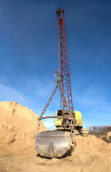 Grande escavadeira com balde duro em areias — Fotografia de Stock