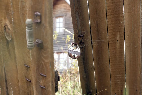 Závěsné kovové zámek na dřevěný plot — Stock fotografie