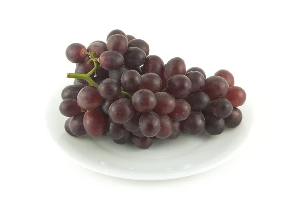 Red grape branch on plate isolated over white close up — Stock Photo, Image